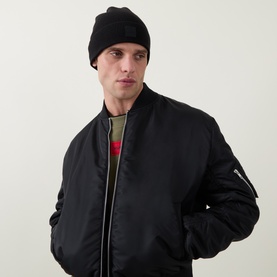 Model with Hugo Boss Fati Ribbed-Knit Beanie Hat in black, styled with a black bomber jacket and khaki top.