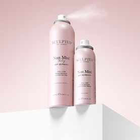 Sculpted by Aimee Sun Mist SPF 50 Spray in two sizes, blush pink aerosol cans with spray mist visible, on white podiums