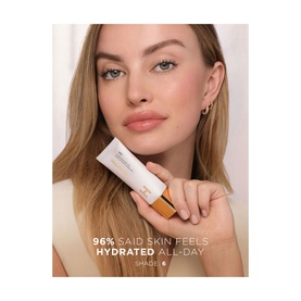 Model holding Hourglass Veil Hydrating Skin Tint 35ml foundation, with on-screen claim: 96% said skin feels hydrated all day