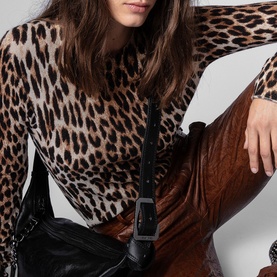 Model carrying Zadig Le Cecilia Shoulder Bag in black leather with branded metal buckle strap, styled with leopard-print top and brown trousers