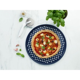 Zyliss Durable Non-Stick Pizza Tray in blue with white polka dots, holding a freshly baked pizza, styled with a pizza cutter and fresh basil