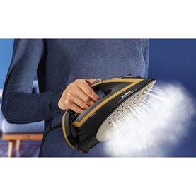 Tefal Ultimate Turbo Pro black steam iron held in hand, releasing powerful steam burst from soleplate