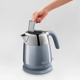 Delonghi Blue Luminosa Kettle in blue with textured body, shown with hand inserting filter into open lid