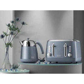 Delonghi Blue Luminosa Kettle in blue with diamond-textured finish, styled alongside matching 4-slice toaster on glass shelf with floral decor