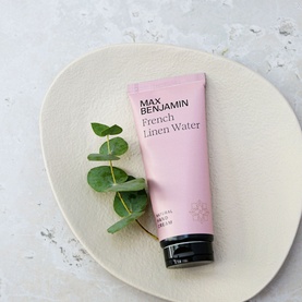Max Benjamin Natural Hand Cream French Linen Water 75ml in pink tube, styled on a ceramic plate with eucalyptus leaves