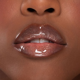 Close-up of lips wearing Kash Beauty Lip Oil in a glossy warm brown-nude finish, giving a plump, high-shine effect