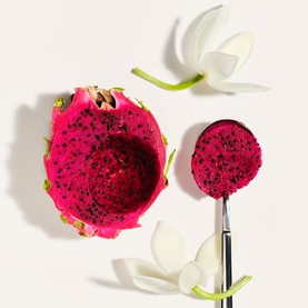 Sol De Janeiro Beija Flor Elasti-Cream ingredient shot featuring halved dragon fruit and white flowers on a light background
