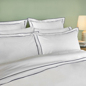 Karla Bree Rome Duvet Cover in white with navy double-stitch border detail, styled with matching pillowcases on a bed