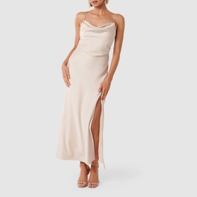 Model wearing Forever New Remy Tie-Back Satin Dress in cream, featuring cowl neckline, spaghetti straps and thigh-high split maxi skirt