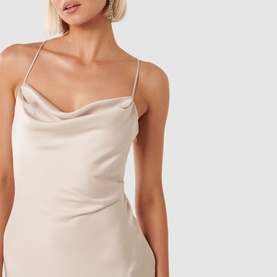 Model wearing Forever New Remy Tie-Back Satin Dress in cream, showing cowl neckline and delicate spaghetti straps with crossover detail
