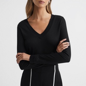 Model wearing Reiss Brady Top in black, featuring V-neckline, long sleeves with layered cuffs and tonal stitching