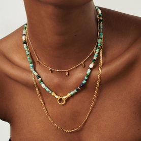 Model with Missoma In Good Hands Beaded Gemstone Necklace in gold with multicolour gemstone beads, styled with layered gold chain necklaces