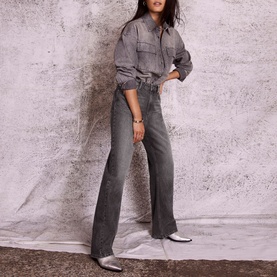 Model wearing Mint Velvet High-Rise Relaxed Wide Leg Jeans in grey with twisted seam, styled with a grey denim shirt and white shoes