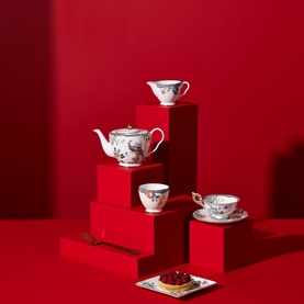 Wedgwood Fortune Teacup Saucer 150ml in multi colourway, styled with matching teapot and sugar bowl on red geometric display steps