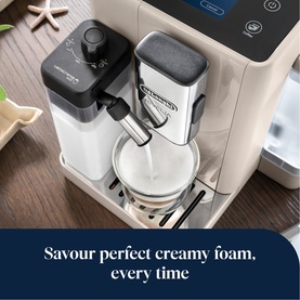 DeLonghi Rivelia Automatic Compact Bean To Cup in beige, dispensing creamy milk foam into a glass cup.