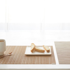 Chilewich Rib Weave Rectangle Placemat in yellow, styled on a white table with toast on a plate and a coffee cup alongside
