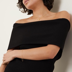 Model with Missoma Orb Chain Bracelet in gold, delicate chain with bobble detail, worn with matching gold necklace and black off-shoulder top