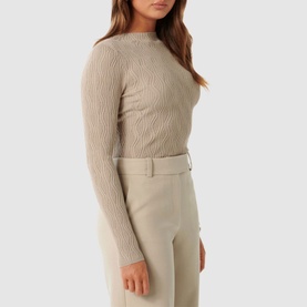 Model wearing Forever New Everley Wave Top in beige with mock neckline and wave pattern, styled with matching beige tailored trousers