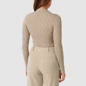 Model wearing Forever New Everley Wave Top in beige, mock neck, long sleeves, wave knit texture, styled with cream tailored trousers. Back view