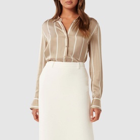 Model wearing Forever New Harvey Striped Shirt in beige with white stripes, collared neckline and button fastening, styled with a cream midi skirt