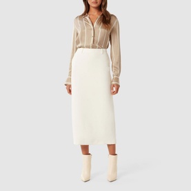 Model wearing Forever New Harvey Striped Shirt in beige with collared neckline, paired with cream midi skirt and ankle boots
