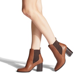 Model wearing Carvela Toodle Heeled Chelsea Boots in beige synthetic leather with block heel, elasticated side panel and pull-tab detail