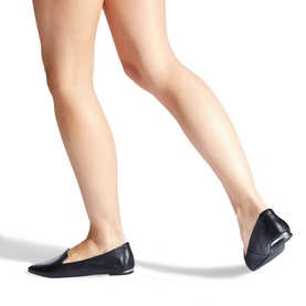 Model wearing Carvela Landed 2 Flats in black leather, pointed toe slip-on style with low vamp and logo detail