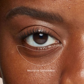 Bobbi Brown Skin Corrector Stick in Very Deep Bisque applied under-eye, with dotted outline showing coverage area and Neutralize Discoloration label