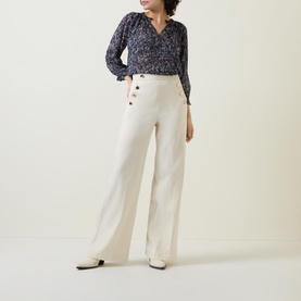Model wearing Part Two Elsia Floral Relaxed Fit Blouse in Navy, styled with cream wide-leg trousers and white heeled mules
