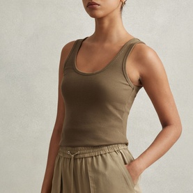 Model wearing Reiss Violet Ribbed Tank Top in green with scoop neckline and fitted silhouette, styled with wide-leg trousers