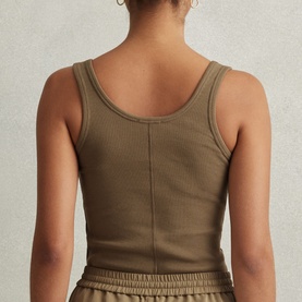 Model wearing Reiss Violet Ribbed Tank Top in green, showing rear seam detail and scoop back, styled with matching green shorts