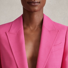 Model wearing Reiss Hewey Single-Breasted Blazer in pink with textured finish and peak lapels, close-up detail view
