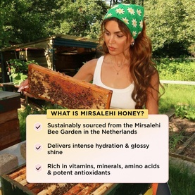 GISOU Honey Infused Hair Perfume Wild Rose edition; model holds honeycomb frame at Mirsalehi Bee Garden, Netherlands