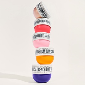 Sol De Janeiro Delicia Drench Body Butter stacked with four other Sol De Janeiro body butter pots in pink, red, orange and purple