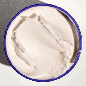 Sol De Janeiro Delicia Drench Body Butter, open jar showing thick cream texture with blue rim, overhead view