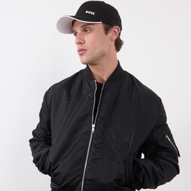Model with Hugo Boss Bold Logo Baseball Cap in black, six-panel design with contrast logo detail, styled with black bomber jacket
