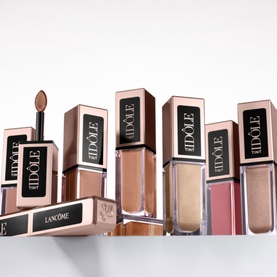 Lanc&ocirc;me Id&ocirc;le Tint Liquid Eye Blusher collection displayed upright, showing multiple nude and rose shade variants in rose-gold packaging