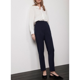 Model wearing Mint Velvet Blue Slim-Leg Tailored Trousers with white blouse and black flat shoes
