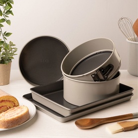 Mary Berry Wooden Spoon 24cm in brown acacia, shown alongside bakeware set including round cake tins and baking tray in a kitchen setting