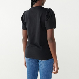 Model wearing Twist & Tango Isa Regular Fit T-Shirt in black, short puff sleeves, round neckline, back view, styled with blue jeans