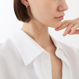 Model with Kate Spade Pav&eacute; Huggies Earrings in rose gold, featuring cubic zirconia crystal detailing, styled with a white shirt