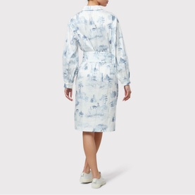 Model wearing Helen McAlinden Odette Toile de Jouy Shirt Dress in blue, rear view, with tie waist and long sleeves. Styled with white trainers