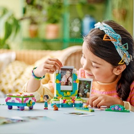 Lego Encanto Mirabel's Photo Frame and Jewellery Box multicoloured set, shown with child building the photo frame with bracelet pieces nearby