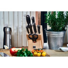 Zwilling Gourmet 9-Piece Bamboo Knife Block in beige, displayed on a kitchen counter styled with herbs, vegetables and a pepper grinder