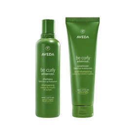 Aveda Be Curly Advanced Shampoo and Conditioner duo in green packaging, shown side by side on white background.