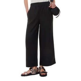 Model wearing Whistles Linen Relaxed Fit Trousers in black, wide-leg cut with elasticated waistband, styled with brown sandals and a round bag