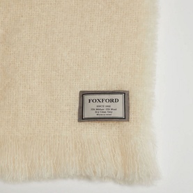 Foxford Off-White Mohair Throw with logo badge detail, fluffy mohair texture and cut fringed trim visible at edge