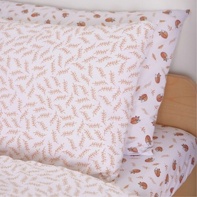 Foxford 200 Thread Count Fauna Pillowcase in white cotton with delicate leaf and ladybird print, shown styled on a children's bed