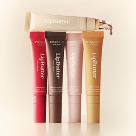 Kylie Cosmetics Lip Butter lip balms in four shades: red, brown, nude pink, and gold, with one tube displayed upright behind.