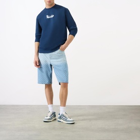 Model wearing Daily Paper Scratch Logo Sweatshirt in blue with light blue check shorts and grey trainers